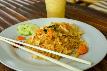 Pad thai noodles with chicken, carrot, shallots and cucumber.