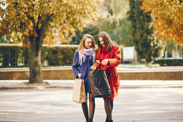 two beautiful and stylish girlfriends walking around the spring city with packages and shopping