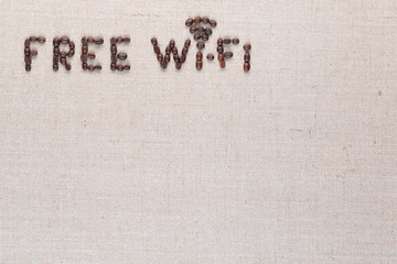 Free wifi sign made from coffee beans on linea background, shot top view, aligned top left.