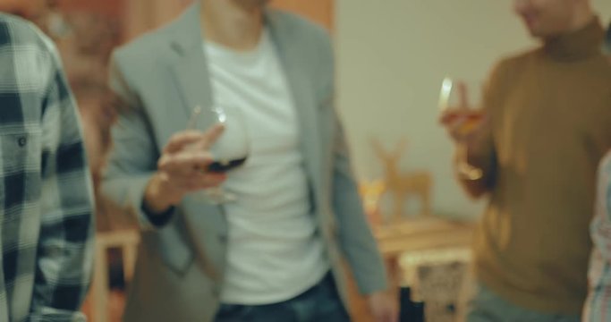 Friends chek glasses and drink. Merry company celebrates the holiday.