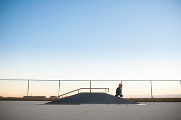 Little boy coming down ramp at skate park on his hover board