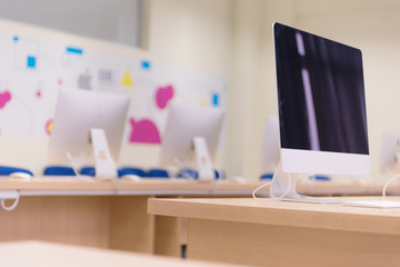 Modern office with computers on desks. Empty computer room in college. Interior of classroom with computers. Concept of corporate working space.