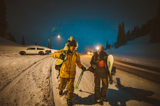 skier and snowboarder make it back to car at end of long ski day