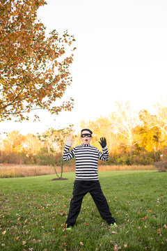 Tween Boy Dressed as a Robber for Halloween, Posing in Yard at Sunset