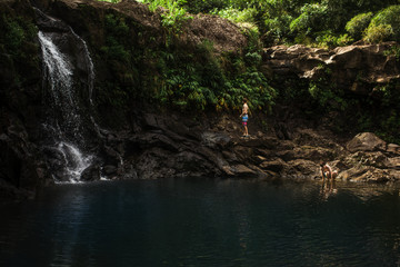 Two boys in a waterfall pool in Maui