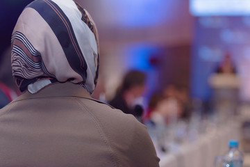 Business muslim woman as leader speaking at Conference. Audience at the conference room or hall , representing model of economic development and startup business and interreligious relations.