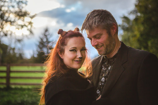 A happy woman in a fox costume hugs her husband at sunset