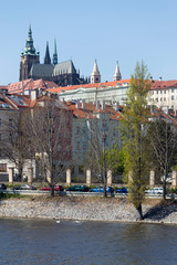 Spring green Prague Lesser Town with gothic Castle above River Vltava in the sunny Day, Czech...