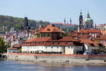 Spring green Prague baroque St. Nicholas' Cathedral with the Lesser Town above River Vltava in the...