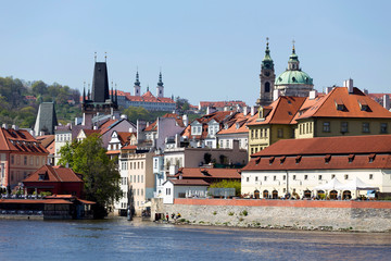 Spring green Prague baroque St. Nicholas' Cathedral with the Lesser Town above River Vltava in the...