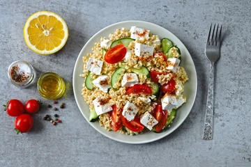 Middle Eastern cuisine. Vegetarian salad with bulgur, vegetables and feta cheese. Fresh bright arabic salad. Tabbouleh salad.
