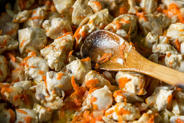 Cooking, sliced carrots and meat fried in a pan