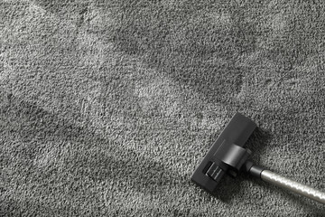 Removing dirt from grey carpet with vacuum cleaner, top view. Space for text