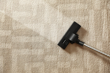 Removing dirt from light carpet with vacuum cleaner, top view. Space for text