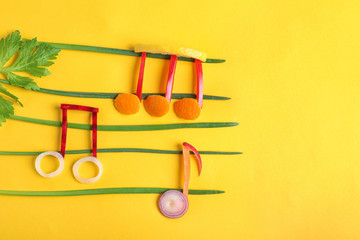 Musical notes made of vegetables and fruits on color background, top view. Space for text
