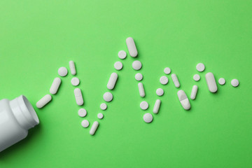 Bottle and heartbeat diagram of pills on color background, flat lay