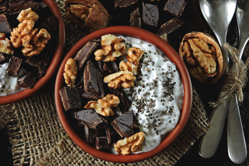Keto breakfast or dessert. White yogurt with chia, walnuts and dark chocolate. Useful energy food. Eco food. Superfoods