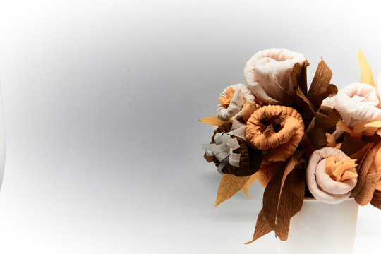 Bouquet of flowers made of couche gift paper insulated on a white and blurred background.