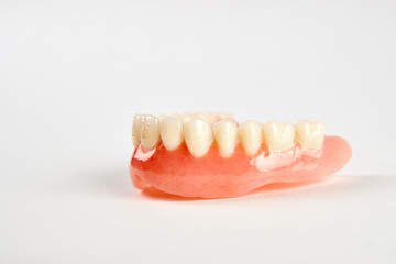 Fototapeta na wymiar Artificial teeth on a white background with copy space, close-up