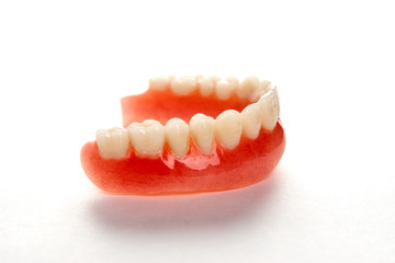 Artificial teeth on a white background with copy space, close-up
