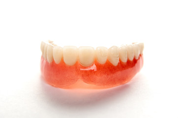 Artificial teeth on a white background with copy space, close-up