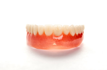Artificial teeth on a white background with copy space, close-up