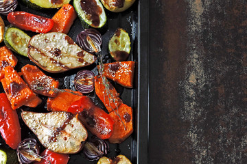 Baked vegetables and fruits on a baking sheet. Vegan theme. Appetizing baked vegetables and fruits...