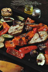 Baked vegetables and fruits on a baking sheet. Vegan theme. Appetizing baked vegetables and fruits with spices.