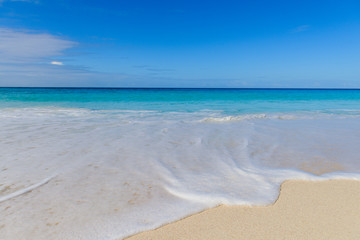 Fototapeta na wymiar Waves and foam on Seychelles paradise beach