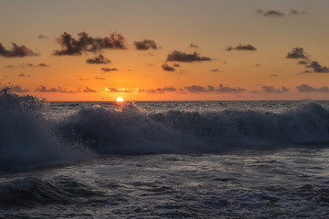 Seychelles coast with water spray at sunset light