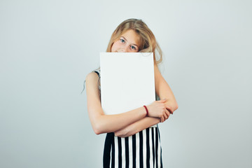 Blond teen girl embracing poster template, grey wall on background. Beautiful girl with blank empty...