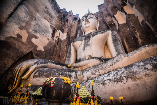 Old buddha statue on wall in ancient temple thailand Sukhothai historical park