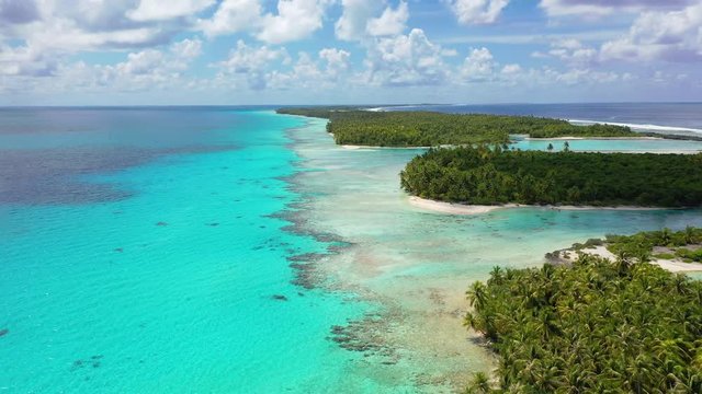 Drone aerial video of Rangiroa atoll island motu and coral reef in French Polynesia, Tahiti. Amazing nature landscape with blue lagoon and Pacific Ocean. Tropical travel paradise in Tuamotus Islands.