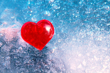 Fototapeta premium Red glass heart on ice. Close-up. Background. Texture.