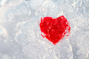 Cold heart. Red heart and frozen water. Close-up. Background. Texture.