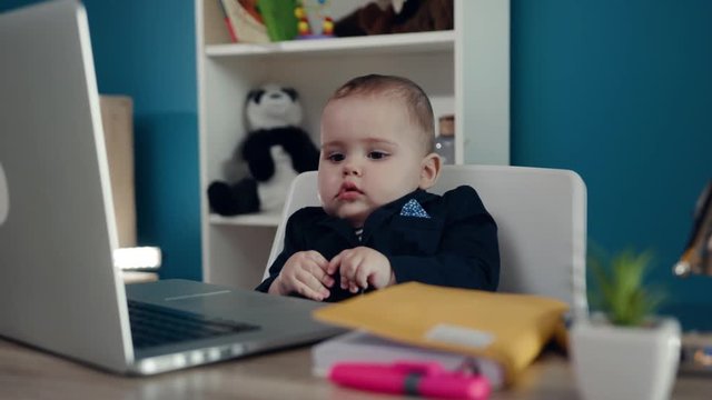 Portrait businessman boss in office use laptop write notebook sitting play creative little happy job work child computer education young suit cute career confident close up slow motion