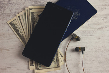 passport money with phone and earphone on the table