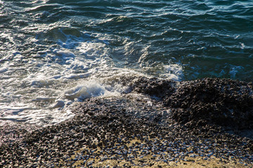 Fototapeta na wymiar Sea wave splash on rocky beach