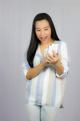 cute beautiful woman in shirt acting playing on phone.  Isolated on gray background