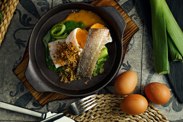 Atlantic cod served with soft boiled egg and vegetables.