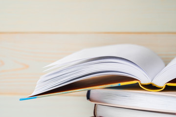 A stack of books on a wooden background.
