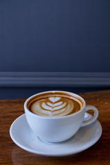 Cup of coffee latte art on the wood desk