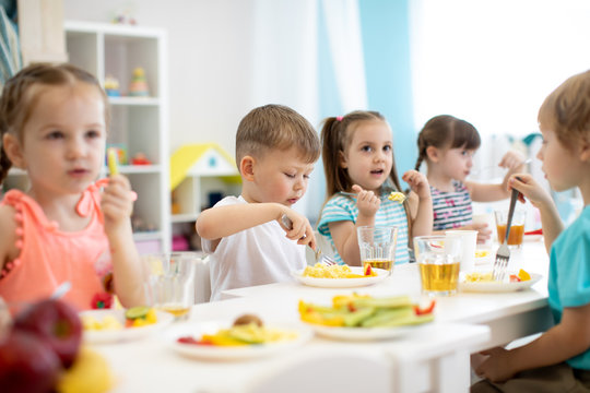 Group of preschool kids have a lunch in daycare. Children eating healthy food in kindergarten