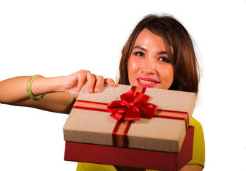 young happy and beautiful Asian Indonesian woman opening Christmas or birthday gift box with red ribbon excited and cheerful smiling isolated on white