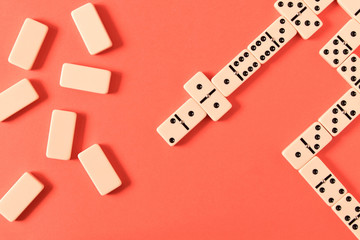 Playing dominoes on a red background. Domino effect.