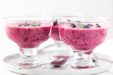 Homemade yogurt with black currants. Summer healthy dessert in glass bowls