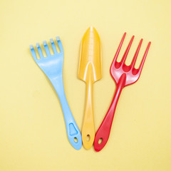 Garden tools, shovel, rake on a yellow background, flat lay
