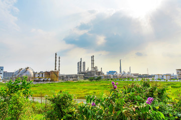 Obraz premium Oil refineries and storage tanks in the plant under the background of blue sky white clouds