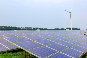 Solar power photovoltaic panels and wind generator under the blue sky white clouds.