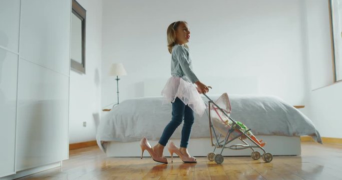 Authentic shot of little girl is playing with stroller toy and doll is playing in her parents bedroom